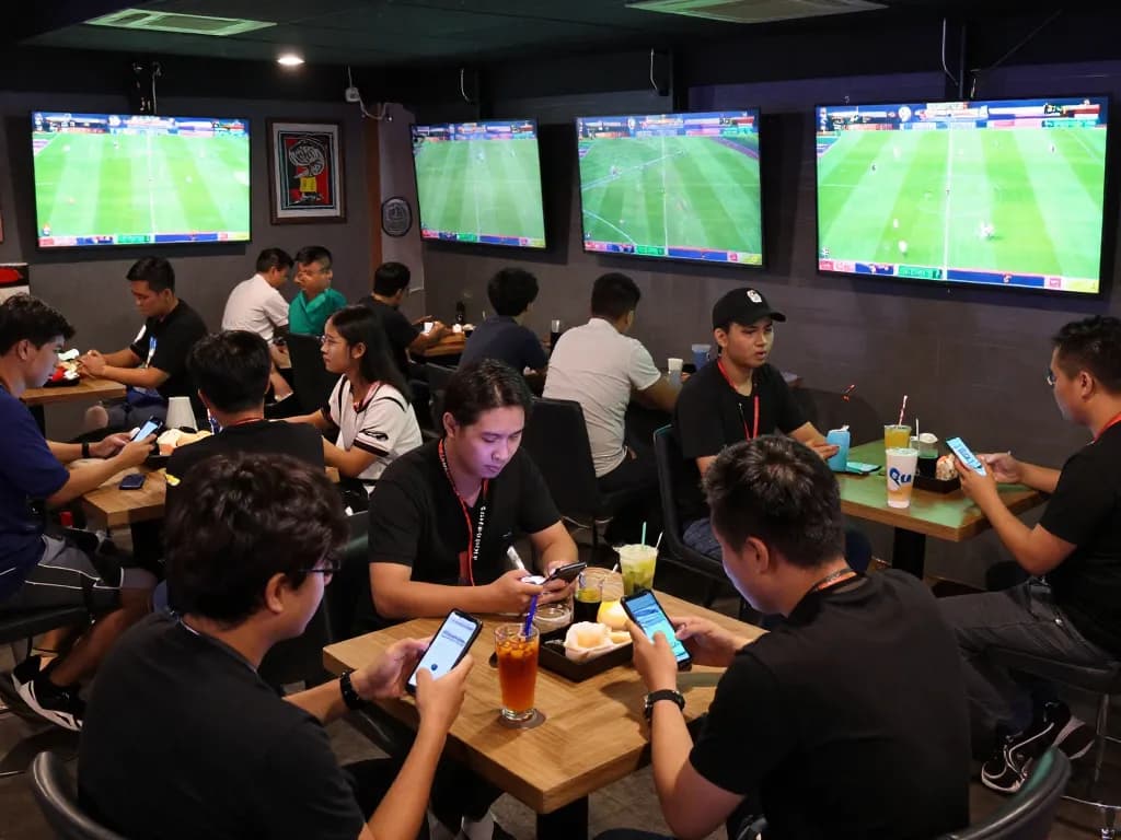 Cá Độ Bóng Đá excitement in a vibrant sports betting lounge with fans and live games.